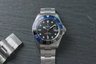 Rolex GMT-Master II Bruce Wayne posée sur une surface en ardoise avec détail du cadran et de la lunette céramique bicolore bleue et noire