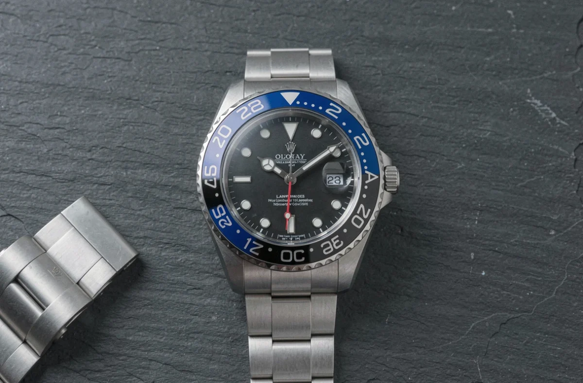 Rolex GMT-Master II Bruce Wayne posée sur une surface en ardoise avec détail du cadran et de la lunette céramique bicolore bleue et noire